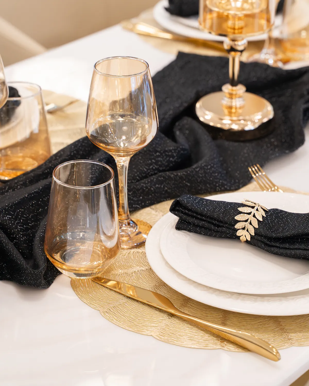 Festlich gedeckter Tisch in Schwarz und Gold bei Élysée Events